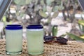 Close up lemonade in blown glass glass on table and desert vegetation in the background, glamping drink desert mexico