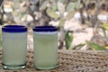 Close up lemonade in blown glass glass on table and desert vegetation in the background, glamping drink desert mexico