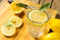 Close-up of lemonade in drinking glass with lemon slices and leaves on cutting board Royalty Free Stock Photo