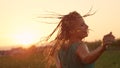 CLOSE UP: Attractive woman in green sundress spins in nature on a rainy morning.