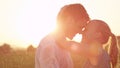 CLOSE UP, LENS FLARE: Beautiful blonde girl wraps her arms behind her handsome boyfriend`s head as they dance in the cool rain at Royalty Free Stock Photo