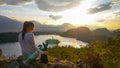 CLOSE UP Young woman observing the stunning lake below her with her adorable dog Royalty Free Stock Photo