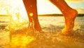 LENS FLARE: Golden sunset shines on barefoot girl walking in shallow sea water. Royalty Free Stock Photo