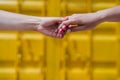 Close up of lesbian couple holding hands in front of yellow background. Love is love . LGBTI concept