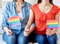 Close up of lesbian couple with rainbow flags