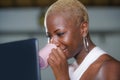 Close up lifestyle portrait of young classy attractive and happy black african american woman drinking coffee or tea working on la Royalty Free Stock Photo