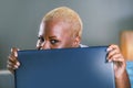 Close up lifestyle portrait of young classy attractive and happy black african american woman posing playful hiding behind laptop