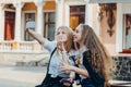 Close up lifestyle selfie portrait of two young positive woman having fun and making selfie, teenage hipster trendy clothes, long Royalty Free Stock Photo