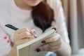 Close up lifestyle soft image and selective focus of pretty young woman sitting on her cozy sofa and making notes Royalty Free Stock Photo