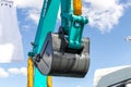 Close-up of lifted bucket of Sunward excavator against the background of the cloudy sky. Construction equipment fair Royalty Free Stock Photo