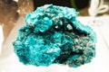 Close up of light blue namibian dioptase stone at trade show illuminated with artificial light