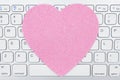 Close-up of a light gray computer keyboard with a pink heart