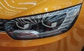 Close up of light headlight of the yellow luxurious sport car.