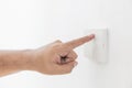 Close-up light switch of a male finger will turn on or off a light switch with white wall at home. white plastic mechanical switch Royalty Free Stock Photo