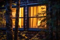 close-up of lighted cabin window in dense woods Royalty Free Stock Photo