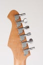 Close up of lightweight chrome tuning machines on neck of electric guitar, studio shoot