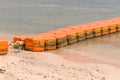 Close up line of dirt sea buoys fasten on sea beach, marine equipment for marking safety zone. Royalty Free Stock Photo