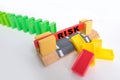 Close-up of a line of dominoes falling, colored cubes of dominoes falling one by one, the concept of risk in business, choosing