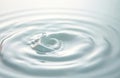 Close-up of liquid drop creating ripples on surface. Fluid with smooth, flowing waves in tranquil, abstract pattern. Light, Royalty Free Stock Photo
