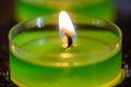 Close up of a lit tea light with green stearine