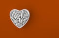 Close-up of lithium orotate capsules. dietary concept: an porcelain bowl in the form of a heart full of lithium orotate capsules.