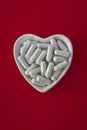 Close-up of lithium orotate capsules. dietary concept: an porcelain bowl in the form of a heart full of lithium orotate capsules.