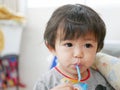 Little Asian baby girl drinking milk from a milk carton by herself Royalty Free Stock Photo