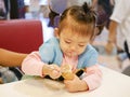 Little Asian baby girl scooping ice cream Royalty Free Stock Photo