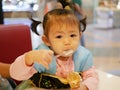 Little Asian baby girl scooping ice cream Royalty Free Stock Photo