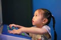 Close-up little Asian child girl playing arcade video game Royalty Free Stock Photo