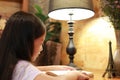 Close-up little Asian girl child in casual clothes reading a book and smiling on the desk in the room Royalty Free Stock Photo