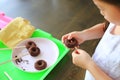 Close up little Asian kid girl in process class of homemade chocolate donuts Royalty Free Stock Photo