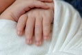 Close-up of little baby handles. The sleeping Newborn boy under a white knitted blanket lies on the blue fur. Royalty Free Stock Photo