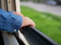 Close up of little baby`s hands holding on a frame of an opened window on a traveling train Royalty Free Stock Photo