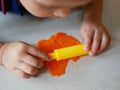 Close up of little baby`s hands rolling on playdough on the house floor