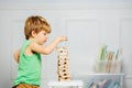 Close-up of boy build a tower playing with Jenga wooden blocks Royalty Free Stock Photo