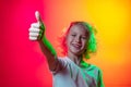 Close-up little boy, cheerful kid looking at camera isolated on red yellow studio background in neon light, filter.