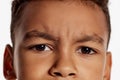 Close-up of little boy face with dark brown eyes expressing emotions. Cropped image. Macro, details