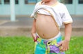 Close up little boy lifting his shirt show exposing his big tummy