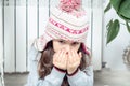 Close up little brunette girl face breathing on hands to keep warm near cold broken heating radiator, looking at camera Royalty Free Stock Photo