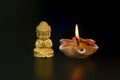 a little Buddha statue and burning candles on a black background Royalty Free Stock Photo