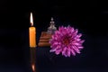 Close-up of a little Buddha statue sitting on a pink lotus flower with a burning candle Royalty Free Stock Photo