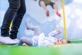 Close up of little cute toddler girl in a dress with mother jumping on a trampoline and laughing. on the children`s