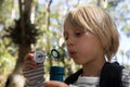 Little girl blowing bubbles on a sunny day in the forest Royalty Free Stock Photo