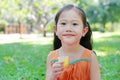 Close up of little girl drinking Orange juice with stained around her mouth in the summer garden Royalty Free Stock Photo