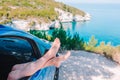 Close up of little girl feet showing from car window background sea Royalty Free Stock Photo