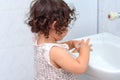 Little cute baby girl cleaning her teeth with toothbrush in the bathroom. Royalty Free Stock Photo