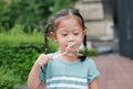 Close up little girl licking lollipop candy in the garden Royalty Free Stock Photo