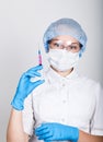 Close-up little girl in a medical dress and gloves holding a syringe Royalty Free Stock Photo