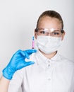 Close-up little girl in a medical dress and gloves holding a syringe Royalty Free Stock Photo